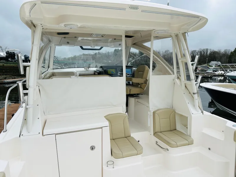 Slide: The Image of 2017 Pursuit OS 355 boat with beige seating and covered helm station. - 4