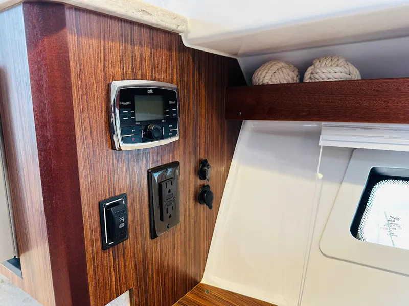 Slide: The Image of Control panel and outlets on 2017 Pursuit OS 355 boat interior. - 45