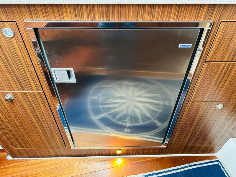 Slide: The Image of Stainless steel cabinet door on 2017 Pursuit OS 355 boat with wood paneling. - 48
