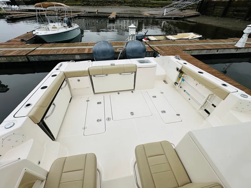 Slide: The Image of 2017 Pursuit OS 355 boat with spacious deck and twin engines docked at marina. - 5