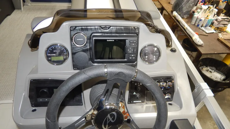 Slide: The Image of 2024 Avalon Venture Quad Lounge Tritoon dashboard with steering wheel and control panel. - 10