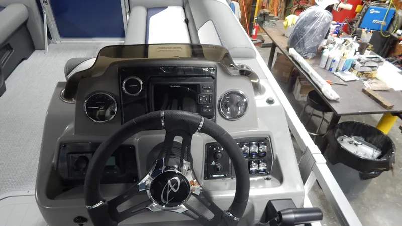 Slide: The Image of 2024 Avalon Venture Quad Lounge Tritoon dashboard with steering wheel and control panel. - 12