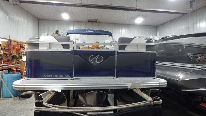 Slide: The Image of 2024 Avalon Venture Quad Lounge Tritoon in a storage facility. - 2