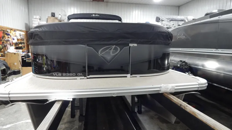 Slide: The Image of 2024 Avalon VLS Quad Lounge 23' pontoon boat in a showroom. - 2