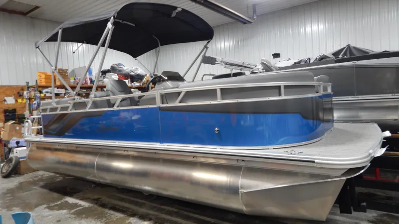 Slide: The Image of 2024 Avalon VLS Quad Lounge 21' pontoon boat in a showroom. - 1