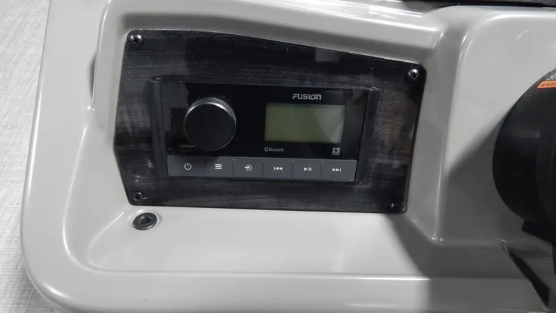 Slide: The Image of 2024 Avalon VLS Quad Lounge 21' boat dashboard with Fusion audio system. - 12