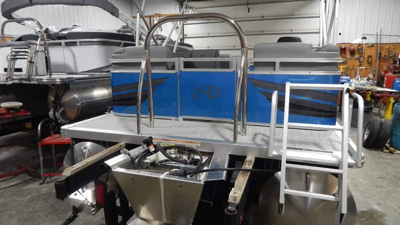 Slide: The Image of 2024 Avalon VLS Quad Lounge 21' pontoon boat in a workshop. - 3