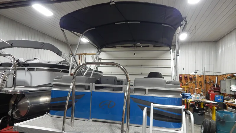 Slide: The Image of 2024 Avalon VLS Quad Lounge 21' pontoon boat in a garage. - 4