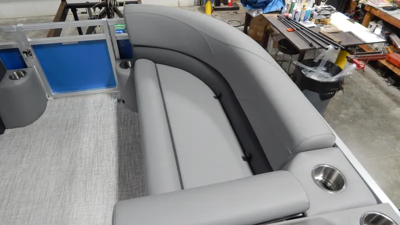 Slide: The Image of 2024 Avalon VLS Quad Lounge 21' boat interior with gray seating and cup holders. - 8