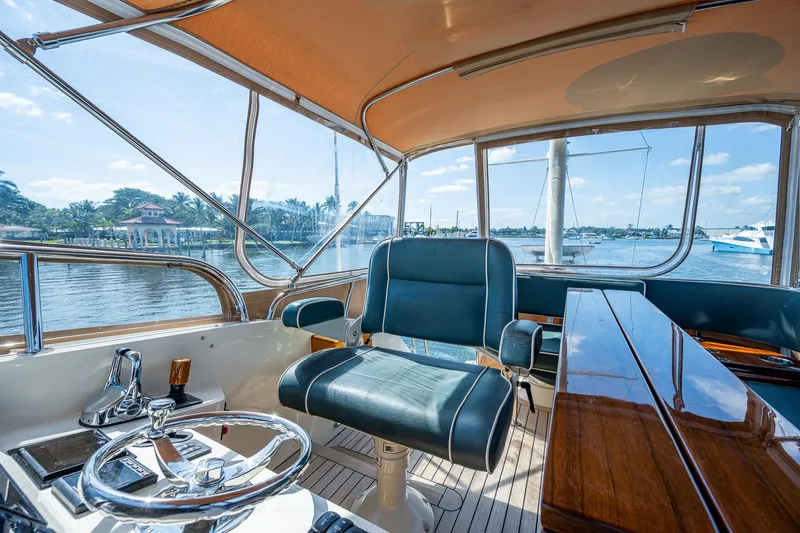 Slide: The Image of 2008 Hinckley Talaria 44 FB yacht interior with steering wheel and seating, overlooking water. - 10