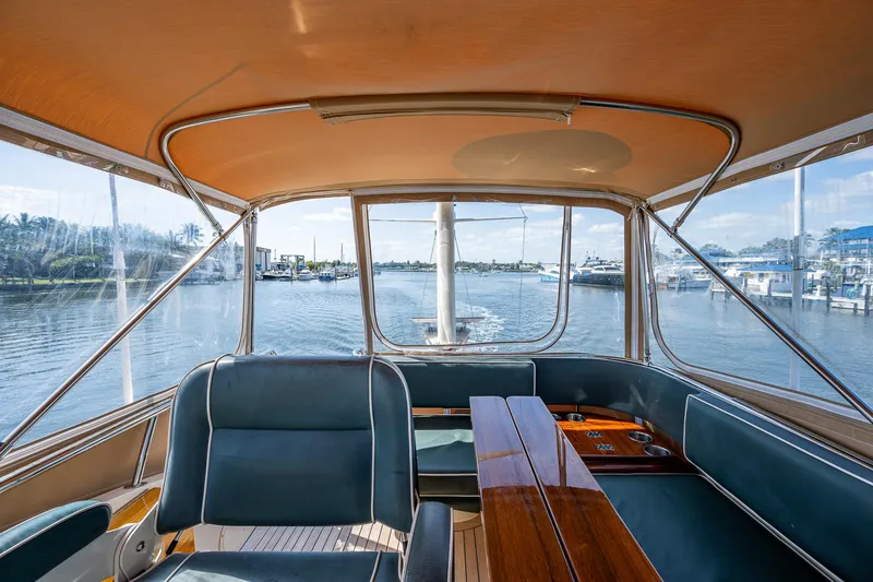 Slide: The Image of 2008 Hinckley Talaria 44 FB yacht interior with waterfront view, featuring elegant seating and wooden table. - 12