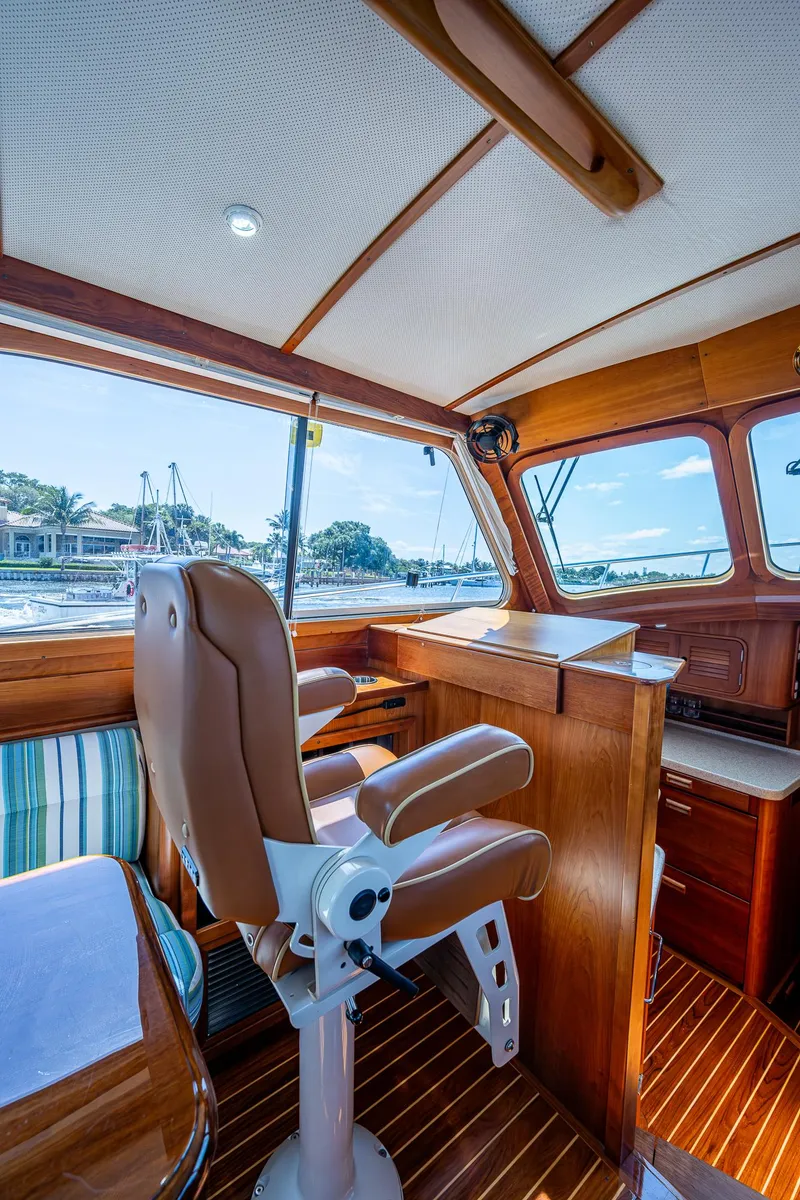 Slide: The Image of Interior of 2008 Hinckley Talaria 44 FB yacht with captain's chair and wooden accents. - 16