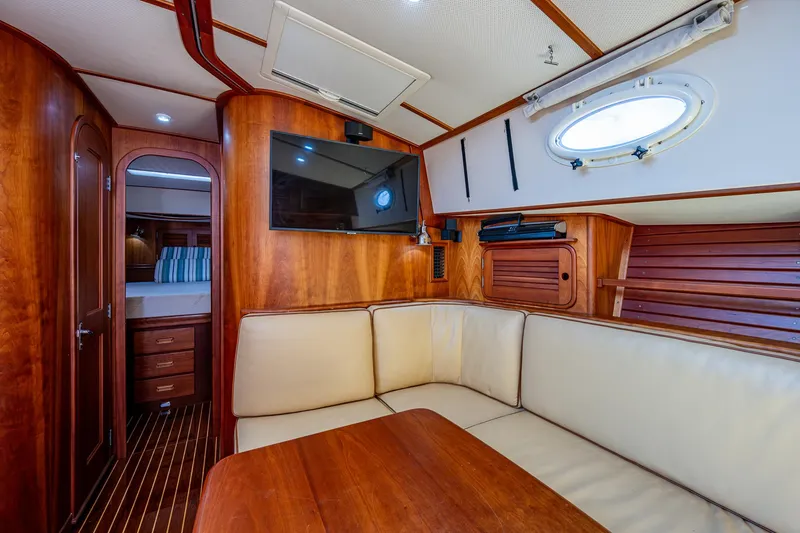 Slide: The Image of 2008 Hinckley Talaria 44 FB yacht interior with wood paneling, cream seating, and a mounted TV. - 28