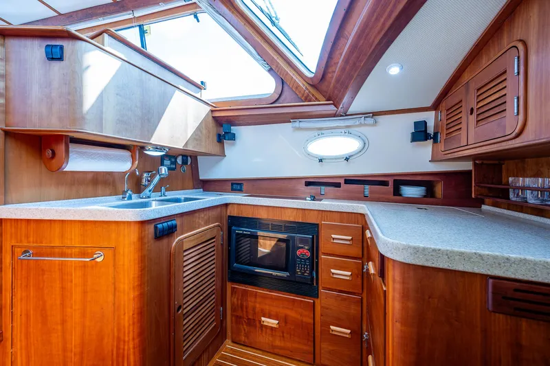 Slide: The Image of Luxurious 2008 Hinckley Talaria 44 FB yacht kitchen with wood cabinetry and modern appliances. - 4