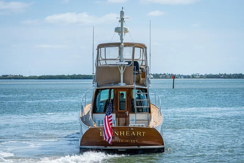 Slide: The Image of 2008 Hinckley Talaria 44 FB yacht on open water, rear view with American flag. - 7
