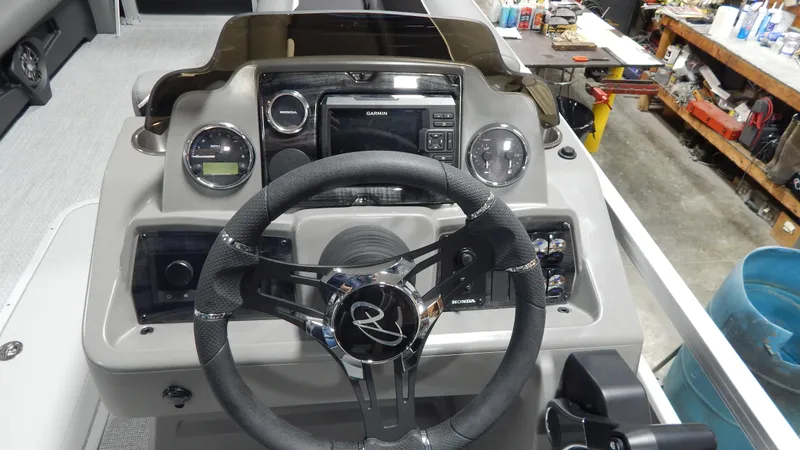 Slide: The Image of 2024 Avalon Venture Cruise Rear Bench 23' boat dashboard with steering wheel and control panel. - 6