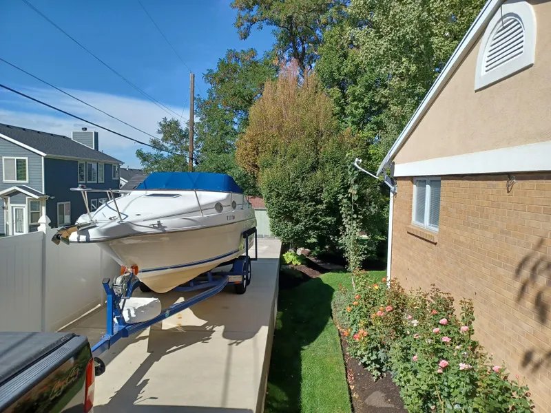 Slide: The Image of 1996 Sea Ray 250 Sundancer boat on trailer in residential driveway. - 3