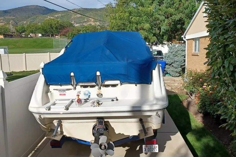 Slide: The Image of 1996 Sea Ray 250 Sundancer boat with blue cover in driveway. - 4