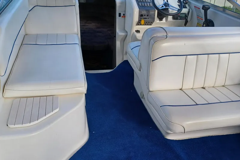 Slide: The Image of 1996 Sea Ray 250 Sundancer boat interior with white seating and blue carpet. - 5