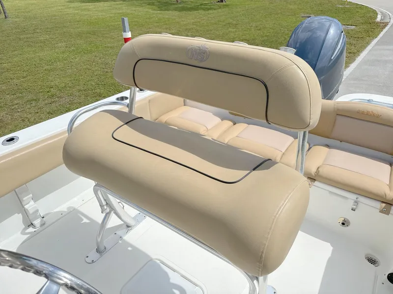 Slide: The Image of 2021 NauticStar 2302 Legacy boat with beige seating and outboard motor. - 16