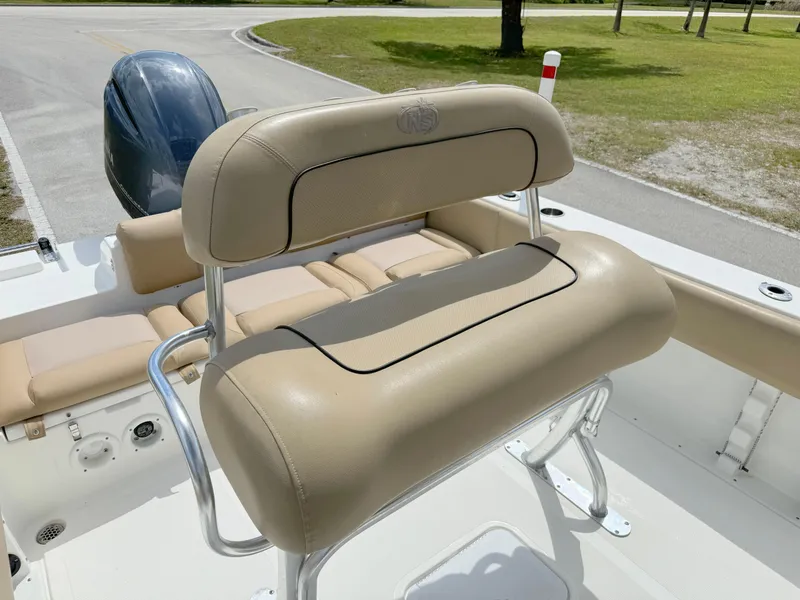 Slide: The Image of 2021 NauticStar 2302 Legacy boat with tan cushioned seating and Yamaha outboard motor. - 17