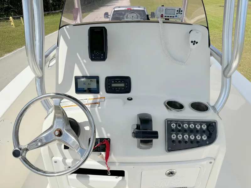 Slide: The Image of 2021 NauticStar 2302 Legacy boat console with steering wheel, controls, and navigation equipment. - 19