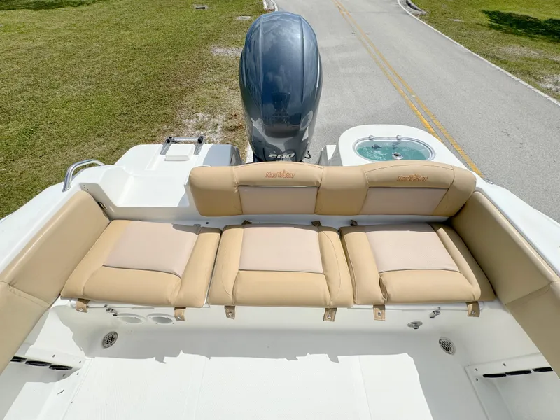Slide: The Image of 2021 NauticStar 2302 Legacy boat with tan seating and outboard motor. - 22