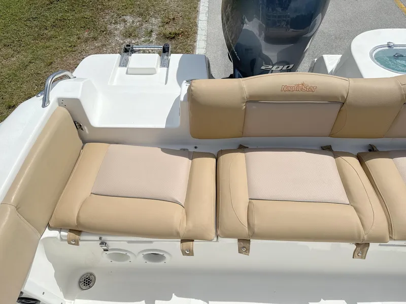 Slide: The Image of 2021 NauticStar 2302 Legacy boat with beige cushioned seating and 200 HP engine. - 23
