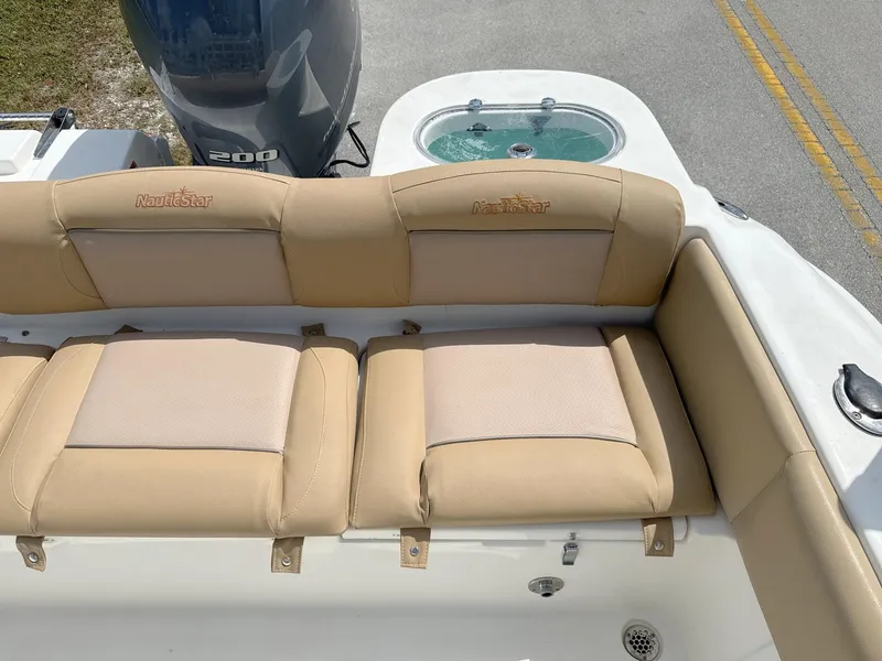 Slide: The Image of 2021 NauticStar 2302 Legacy boat with tan cushioned seating and Yamaha 200 engine. - 24