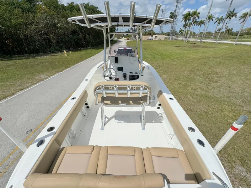 Slide: The Image of 2021 NauticStar 2302 Legacy boat with beige seating and T-top on a sunny day. - 30