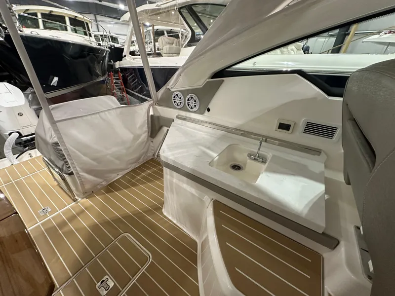 Slide: The Image of 2024 Tiara Yachts 34 LX interior with sleek design, featuring a compact sink and wooden flooring. - 15