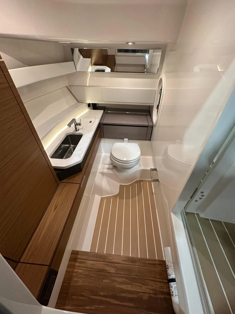 Slide: The Image of 2024 Tiara Yachts 34 LX bathroom with modern fixtures and wood accents. - 24