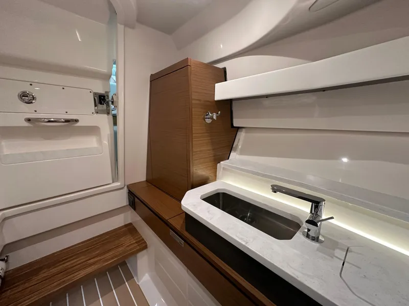 Slide: The Image of 2024 Tiara Yachts 34 LX interior with modern sink and wooden accents. - 26