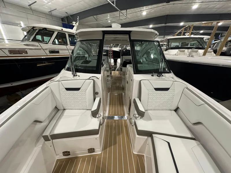 Slide: The Image of 2024 Tiara Yachts 34 LX interior with luxurious seating and sleek design in a showroom. - 29