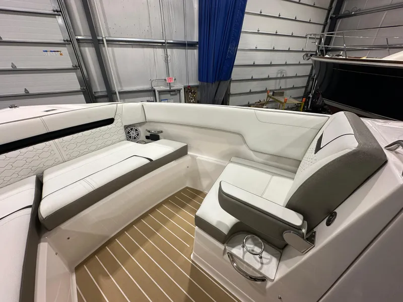 Slide: The Image of 2024 Tiara Yachts 34 LX interior with white seating and wood flooring in a garage setting. - 31