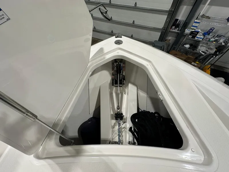 Slide: The Image of 2024 Tiara Yachts 34 LX anchor storage compartment, open in a garage setting. - 32