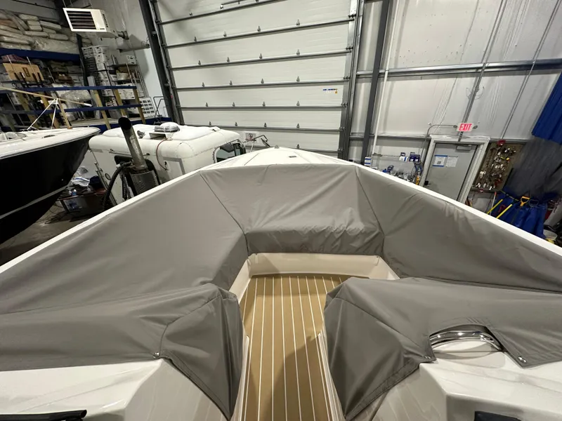 Slide: The Image of 2024 Tiara Yachts 34 LX boat interior with protective covers in a storage facility. - 33