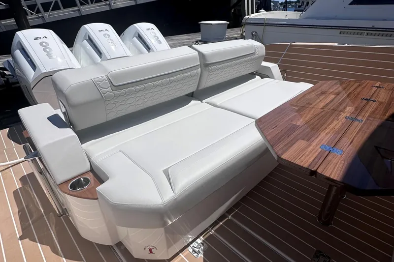 Slide: The Image of 2024 Tiara Yachts 48 LS luxury seating area with wooden table and triple outboard engines. - 12