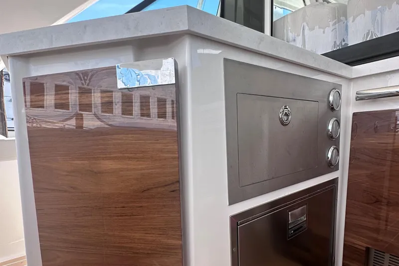 Slide: The Image of Modern kitchen area on the 2024 Tiara Yachts 48 LS with stainless steel appliances. - 16