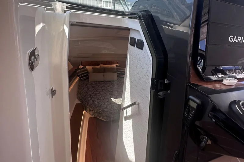 Slide: The Image of 2024 Tiara Yachts 48 LS cabin interior with bed and Garmin navigation system. - 20