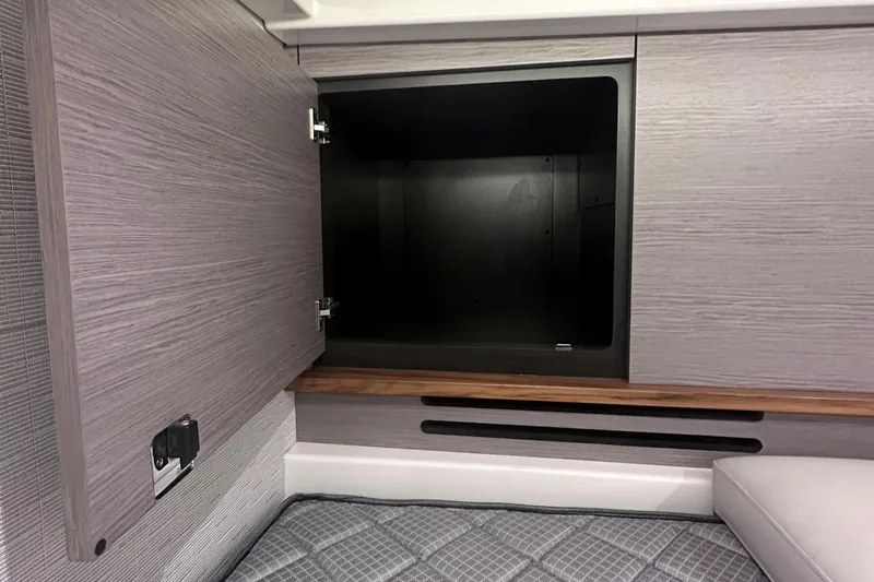Slide: The Image of 2024 Tiara Yachts 48 LS interior storage compartment with open cabinet door. - 32