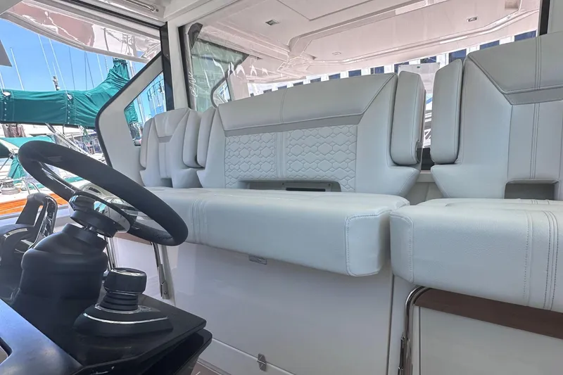 Slide: The Image of 2024 Tiara Yachts 48 LS helm seating area with luxurious white upholstery. - 36
