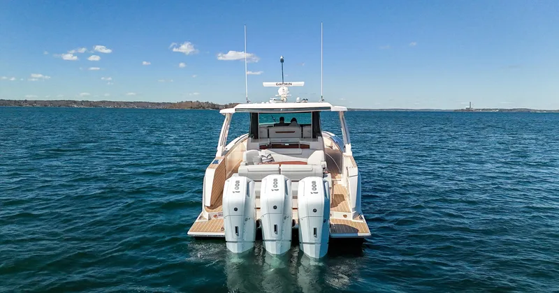 Slide: The Image of 2024 Tiara Yachts 48 LS luxury boat with triple outboard engines on open water. - 9