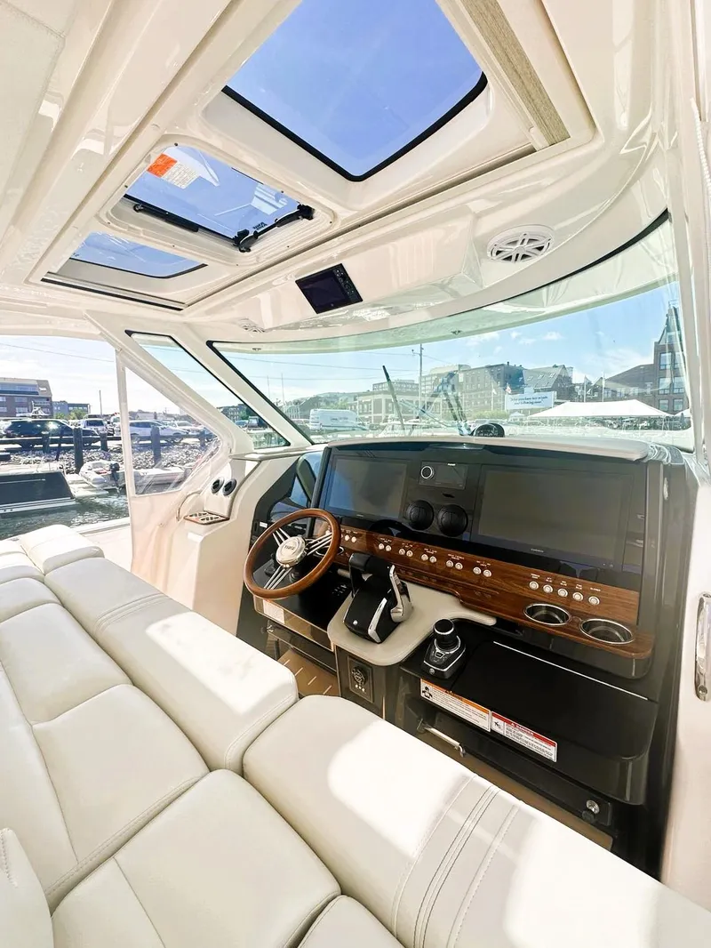 Slide: The Image of 2024 Tiara Yachts 43 LS interior with luxurious seating and modern dashboard. - 29