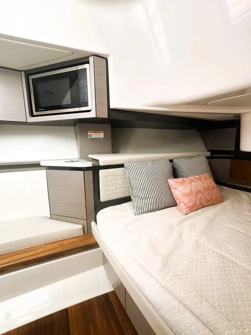 Slide: The Image of 2024 Tiara Yachts 43 LS cabin interior with bed, pillows, and microwave. - 35