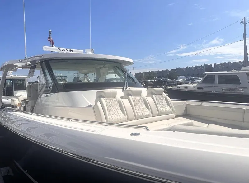 Slide: The Image of 2024 Tiara Yachts 43 LS luxury boat with spacious seating, docked under clear skies. - 6