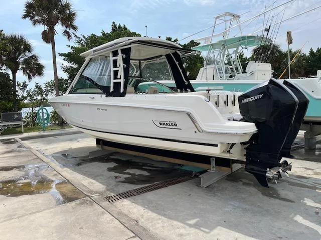 Slide: The Image of 2018 Boston Whaler 270 Vantage boat on a dock with Mercury outboard engines. - 1