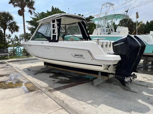 Slide: The Image of 2018 Boston Whaler 270 Vantage boat on a dock with Mercury outboard engines. - 2