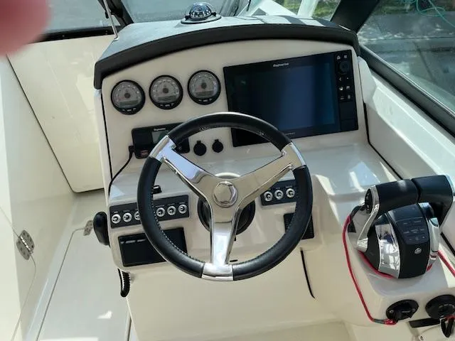 Slide: The Image of 2018 Boston Whaler 270 Vantage helm with steering wheel, gauges, and controls. - 22