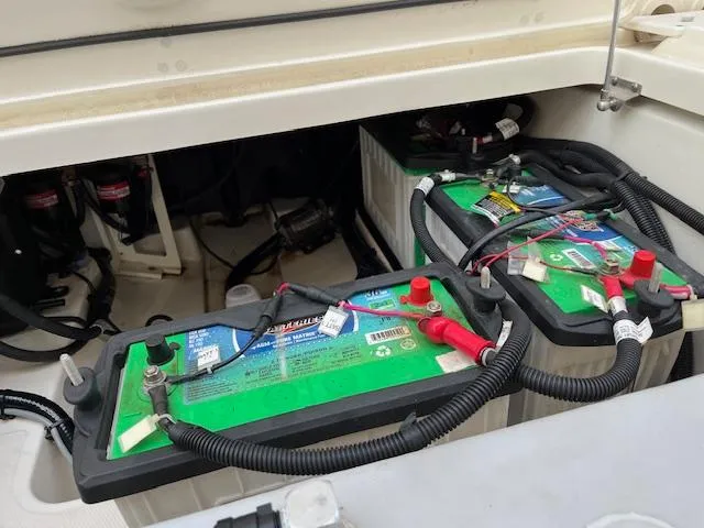 Slide: The Image of 2018 Boston Whaler 270 Vantage boat battery compartment with two green batteries. - 49